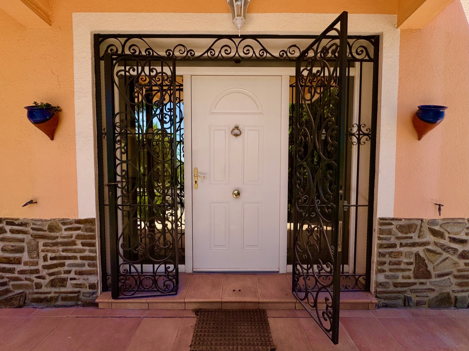 La porte d'entrée et sa grille en fer forgé